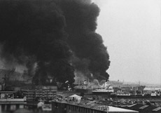 genova in foto, sullo sfondo il fumo nero esce dalla petroliera giapponese Hakuyo Maru