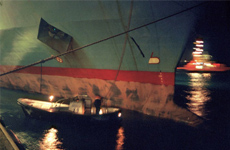 nel turno di notte una motobarca prende il cavo affiancata alla nave 